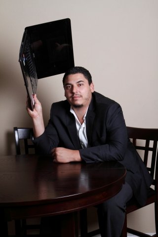 Early business portrait of Guillermo Rivas with his laptop