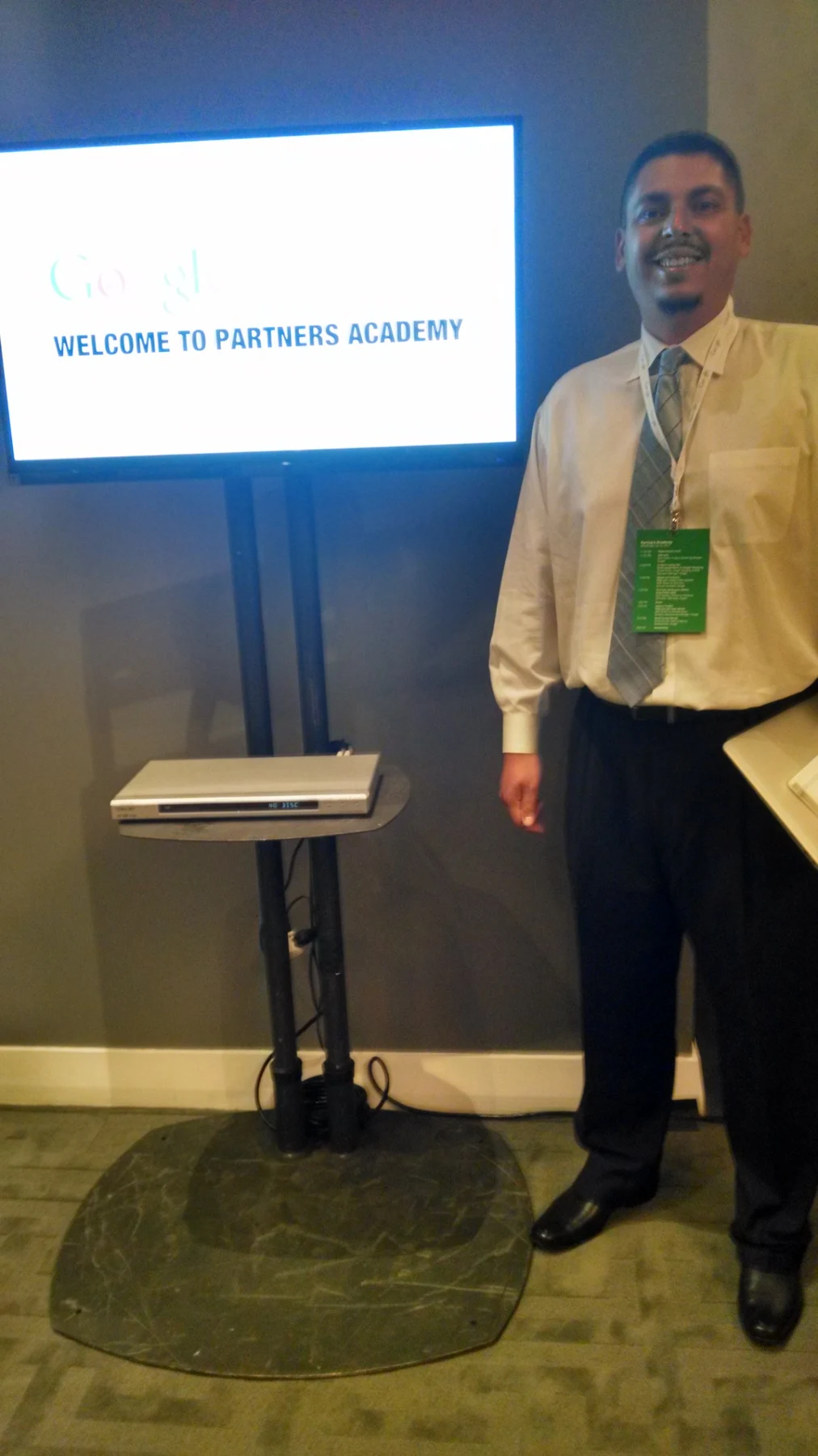 William beside the Welcome to Partners Academy display at Google